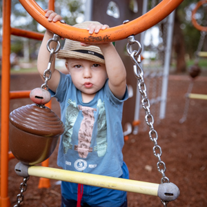 Toddler boy on play equipment