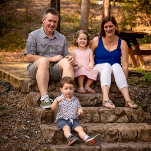 A family sitting on steps in a park for a posed family photo