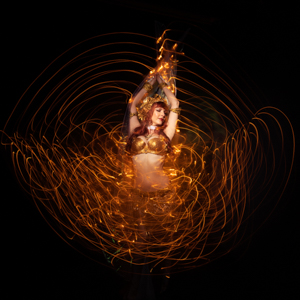 Spiral Orchid fusion belly dancer with LED Isis wings in motion on extended exposure