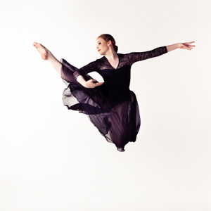 Musical Theatre performer Amelia performing a jump with one leg tucked.